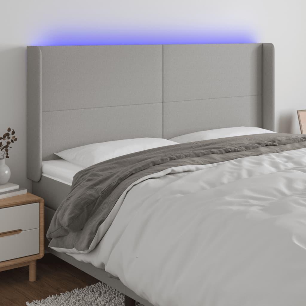 Sengegavl med LED-lys 203x16x118/128 cm stof lysegrå billede